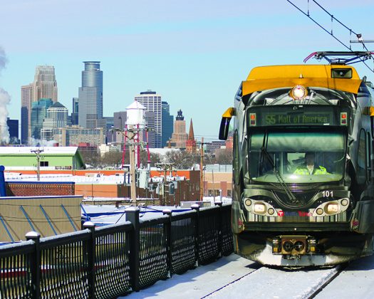 Light rail train with skyline of Minneapolis