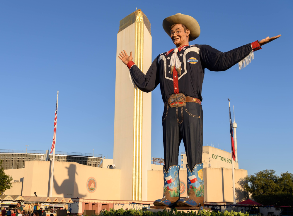 Big Tex cowboy statue stands against a blue sky at State Fair of Texas