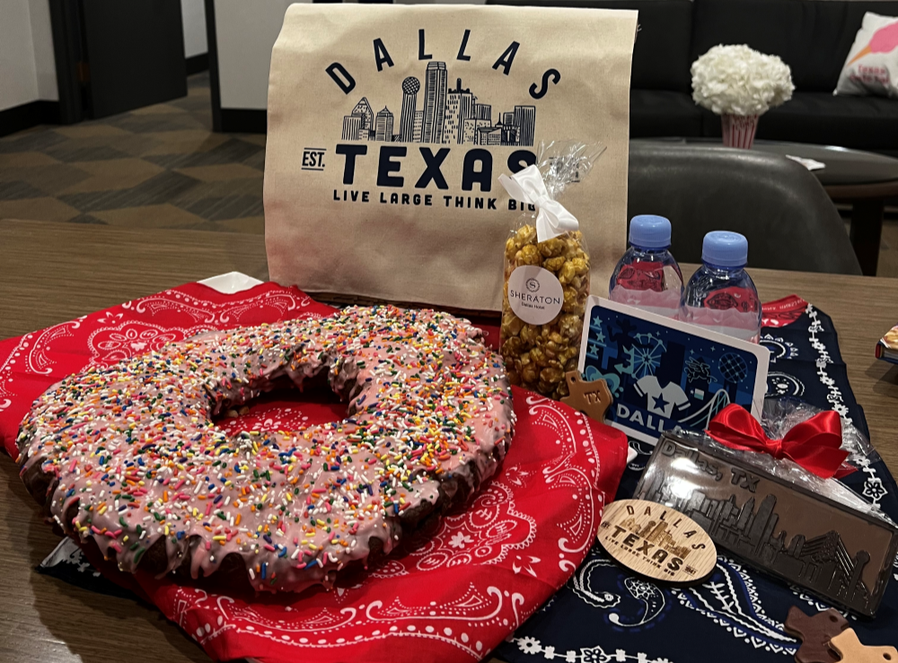 a giant donut and a bag of popcorn along with otherDallas Texas themed items on a table