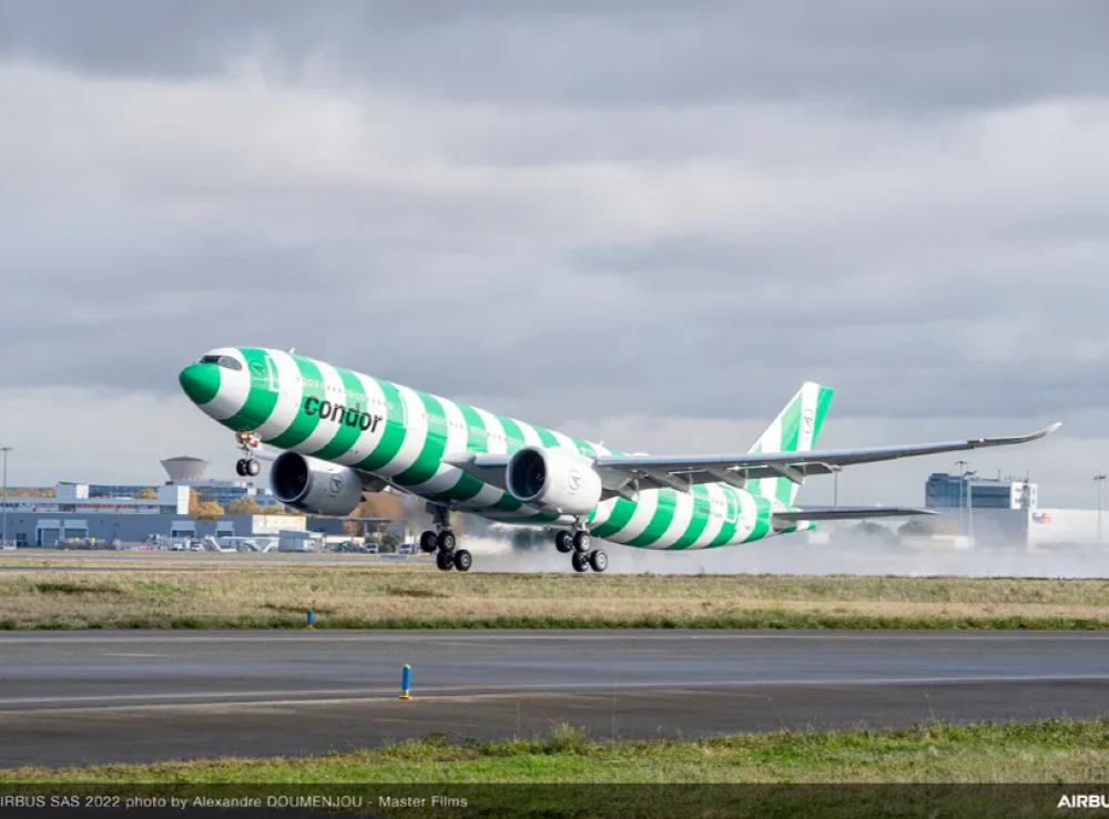 Condor green and white striped airplane on runway