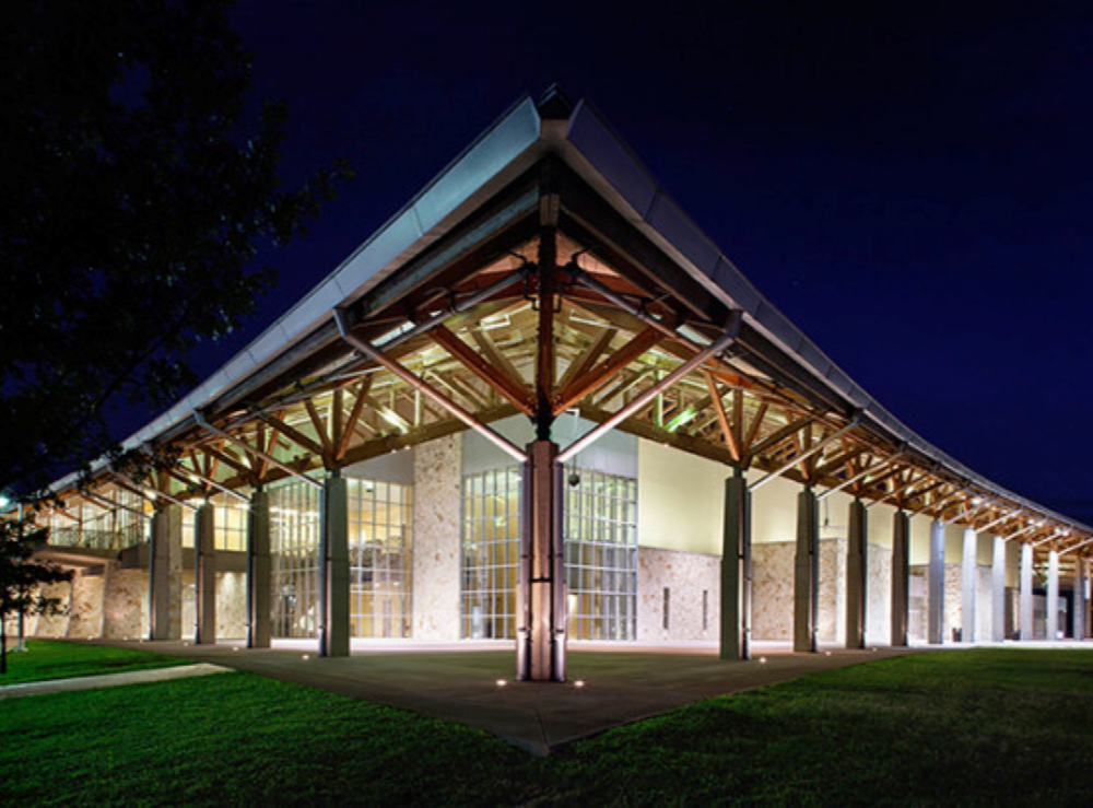 Palmer Event Center with lights on inside against a night sky.