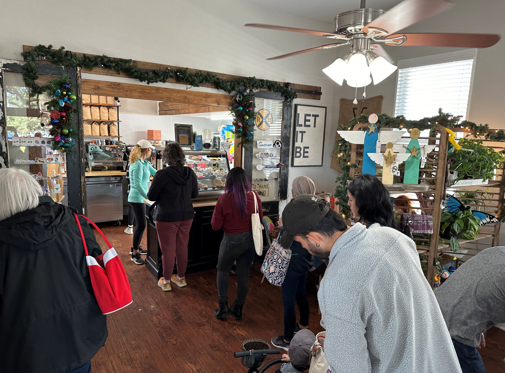 A line of people waits in front of a cafe counter.