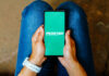 AI-Powered Flight Cancellation Refunds Land at Frontier Airlines A person holds a mobile phone displaying Frontier Airlines' logo