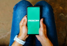 AI-Powered Flight Cancellation Refunds Land at Frontier Airlines A person holds a mobile phone displaying Frontier Airlines' logo